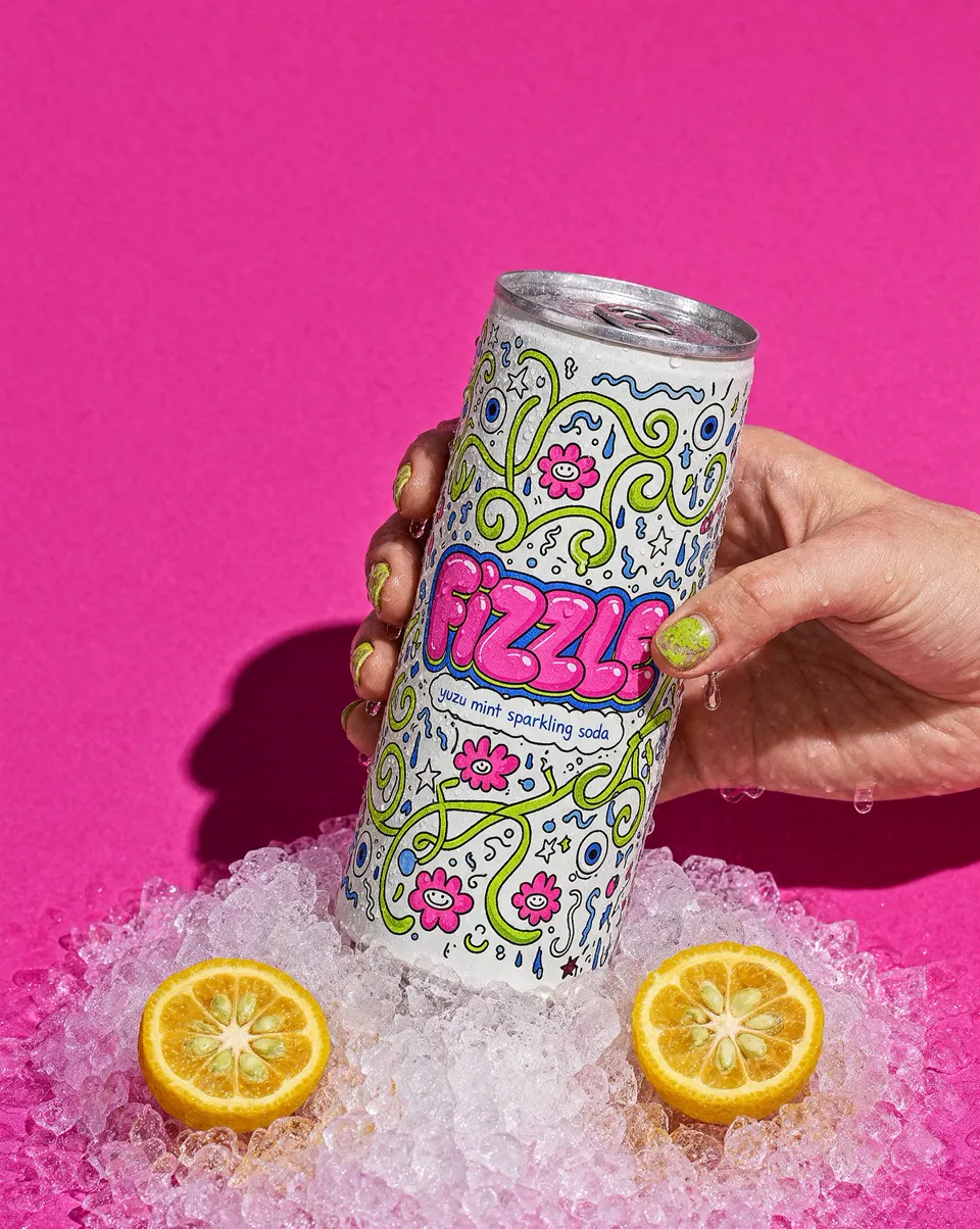 Beverage campaign image of a soda can in crushed ice on a pink backdrop